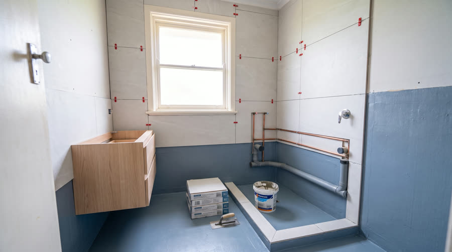 A bathroom mid-renovation with new copper hot water pipework